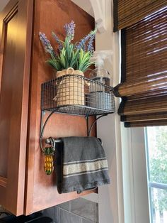 a potted plant sitting on top of a metal shelf next to a kitchen sink