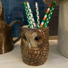 an owl mug with four pencils sticking out of it