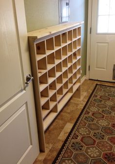 a book shelf sitting in the corner of a room next to a door and rug