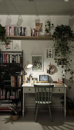 a desk with a laptop computer on top of it next to a bookshelf