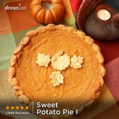 a pumpkin pie sitting on top of a table next to a candle and some other decorations