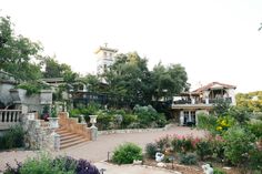 an outdoor garden area with stairs and flowers in the foreground, surrounded by trees