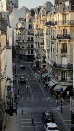 a city street filled with lots of traffic and tall buildings next to eachother