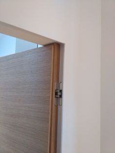 an open wooden door in a white room