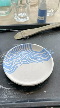 a blue and white plate sitting on top of a table next to a bottle of water