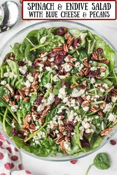 spinach and endive salad with blue cheese & pecans in a glass bowl