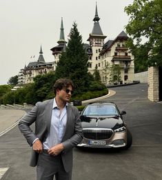 a man in a suit standing next to a car