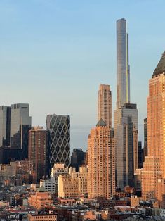 the city skyline with skyscrapers and buildings in the foreground is seen at sunset