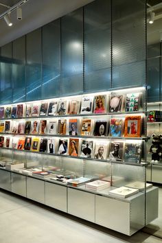 a display case filled with lots of different types of pictures and books on glass walls