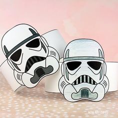 two star wars masks are sitting next to each other on a pink background with white polka dots