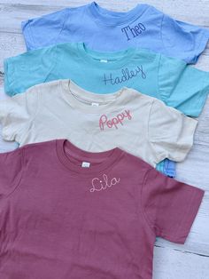 These sweet little toddler t-shirts are the perfect basic for play days. The monogrammed collar is machine embroidered and adds a special personalized touch to a comfortable tee. These are available in sizes 2T-6T, size up for growing room. machine embroidery requires a stabilized backing, this will get softer with wash and wear and become like fabric. it's recommended to wash before wear for softness.  Each tee can be customized with name or short phrase, up to 10 letters is ideal. Font size is approximately 3/4 inch, exact sizing depends on the font and length of name. Thread color can be customized to coordinate with the shirt. If not specified, the default font is Emerson and thread color will be chosen based on shirt color. Kids Monogram Shirts, Personalized Short Sleeve T-shirt For Spring, Family Matching Solid Color Short Sleeve Tops, Family Matching Short Sleeve Tops, Cute Short Sleeve Top With Embroidered Text, Spring Tops With Custom Embroidery, Cute Short Sleeve Tops With Custom Embroidery, Personalized Pink Short Sleeve Tops, Personalized Pink Tops For Spring