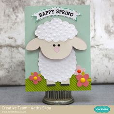 a card with a sheep on it and the words happy spring written in black ink