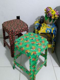 two colorful stools sitting next to each other in a room with tile flooring