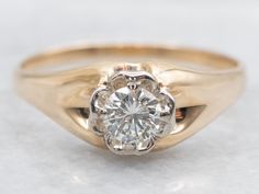 a gold ring with a diamond in the center