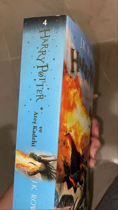 a person holding a harry potter book in their hand