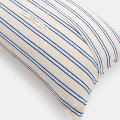 a blue and white striped pillow on a white surface