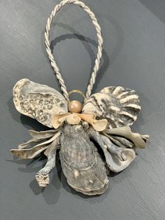 an ornament made out of seashells and rope on a gray wall