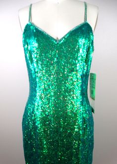 "The color of this one is ELECTRIC! It's fully embellished with iridescent mermaid green sequins all over! It's in perfect condition with the original retail tags still attached and also comes with a small bag of matching embellishments. ABSOLUTELY AMAZING! Bust - 36\" Waist - 28\" Hips - 38\" Length - 35\" Tag Size - 6 This dress comes from a pet-free and smoke-free home. If you would like more info or have any questions, please don't hesitate to ask!" Green Sequined Dresses For Costume Party, Glamorous Holiday Mermaid Dress With Sequins, Green Sequined Holiday Dress, Holiday Green Sequined Dresses, Green Mermaid Dress For Night Out, Green Mermaid Evening Dress For Prom, Glamorous Green Sequined Mermaid Dress, Fitted Green Sequin Dress With Contrast Sequins, Glamorous Green Mermaid Dress With Sequins