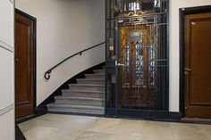 an entrance to a building with stairs and wrought iron gates