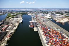 an aerial view of a large cargo ship docked at a dock in the middle of a city