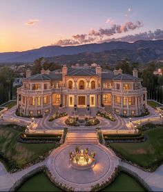 this is an aerial view of a mansion at night with lights on the front and side