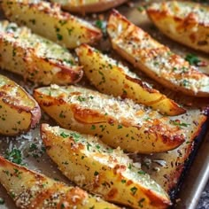 baked potato wedges with parmesan cheese and herbs on top, ready to be eaten