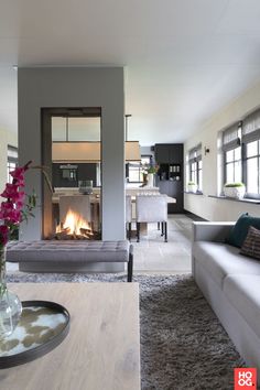 a living room filled with furniture and a fire place in the middle of it's wall