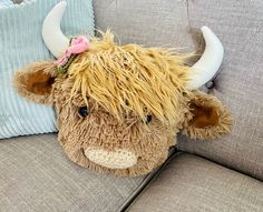 a stuffed animal cow laying on top of a couch