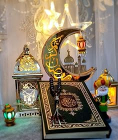 an open book with arabic writing on it and other items around it in front of a curtain