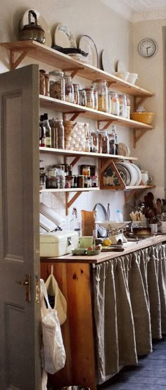 a kitchen filled with lots of clutter next to a window