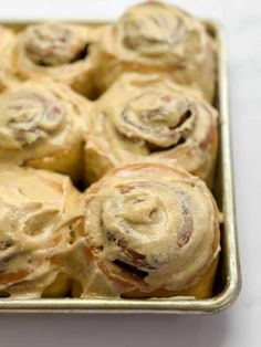 a pan filled with cinnamon rolls on top of a table