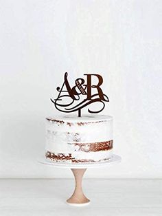 a wedding cake with the initials on it and an acrobatic monogram