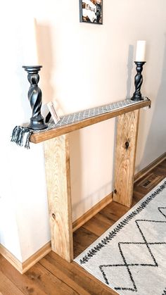 a wooden table sitting on top of a hard wood floor next to a white wall