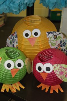 three colorful paper owls sitting on top of a table