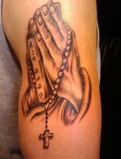 a tattoo on the arm of a person holding a rosary