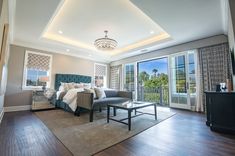 a large bedroom with hardwood floors and white walls, along with sliding glass doors that lead to a balcony