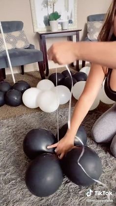 a woman is playing with balloons on the floor