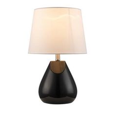 a black and gold lamp with a white shade on the top, in front of a white background