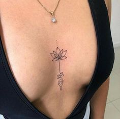 a woman with a lotus tattoo on her upper back and chest, holding a small flower