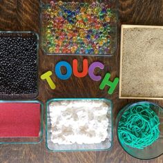 the word touch spelled out in plastic letters next to bowls of beads and other items