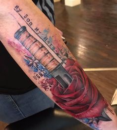 a person with a tattoo on their arm holding a knife and roses in the background