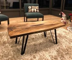 a wooden table sitting on top of a carpeted floor next to two blue chairs