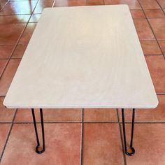 a white table sitting on top of a tiled floor next to a red tile floor