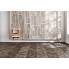 a chair sitting on top of a wooden floor in front of a large wall hanging