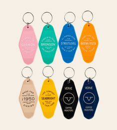 six different colored key chains with the names of various coffee shops and locations on them