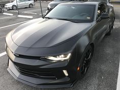 a black chevrolet camaro is parked in a parking lot