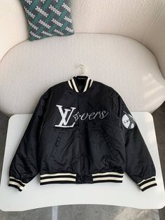 Embrace sporty sophistication with the Louis Vuitton-inspired Embroidered Nylon Baseball Blouson. This statement jacket reimagines classic varsity styling with a luxurious touch. The sleek black nylon is adorned with eye-catching embroidered patches, showcasing "LV Lovers" lettering and playful motifs. The contrasting ribbed collar, cuffs, and hem offer a snug fit and a touch of sporty flair. This versatile blouson is perfect for layering and adds a touch of high-fashion to any casual ensemble. Blouson Jacket, Statement Jacket, Loafer Sneakers, Bottega Veneta Shoulder Bag, Black Nylon, Black Nylons, Embroidered Patches, Brunei, Sneaker Boots