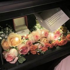 an arrangement of flowers and candles in a box with a note on the inside that says, i do not know what this is