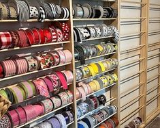 many different types of ribbons are on display in a room with wooden shelves and shelving