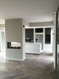 an empty kitchen and living room with wood flooring